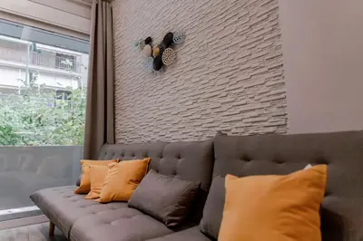 a couch in a living room with a brick wall at Design drop in Athens ' center in Athens