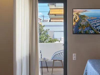 a room with a window with a view of the ocean at YaPe Coastal Suites at Alimos Beach in Athens