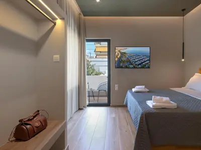 a bedroom with a bed and a large window at YaPe Coastal Suites at Alimos Beach in Athens