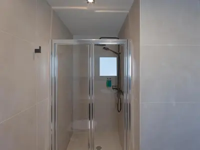 a shower with a glass door in a bathroom at YaPe Coastal Suites at Alimos Beach in Athens