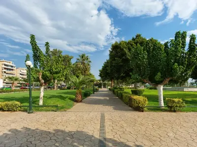 a walkway in a park with trees and grass at YaPe Coastal Suites at Alimos Beach in Athens