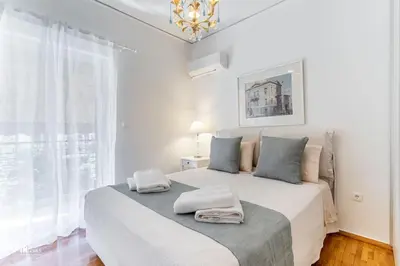 a white bedroom with a large bed with two towels on it at Hephaestus - Luxury & Modern Apartment in Psychiko in Athens