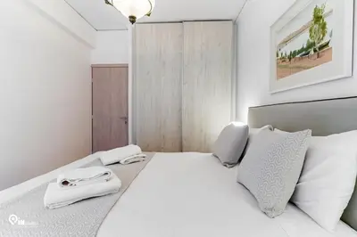 a bedroom with a white bed with white pillows at Hephaestus - Luxury & Modern Apartment in Psychiko in Athens