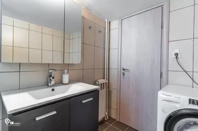 a bathroom with a sink and a washing machine at Hephaestus - Luxury & Modern Apartment in Psychiko in Athens