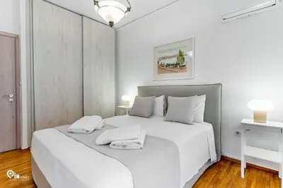 a white bedroom with a white bed with two towels on it at Hephaestus - Luxury & Modern Apartment in Psychiko in Athens
