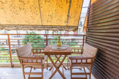 a table with two chairs and a bottle on a balcony at Hephaestus - Luxury & Modern Apartment in Psychiko in Athens