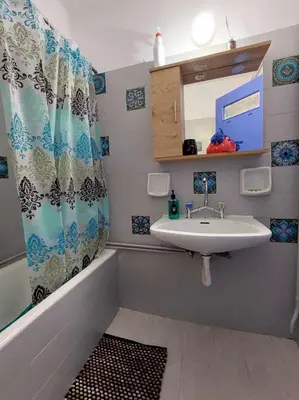 a bathroom with a sink and a shower curtain at Studio By The Beach 2 in Saronida