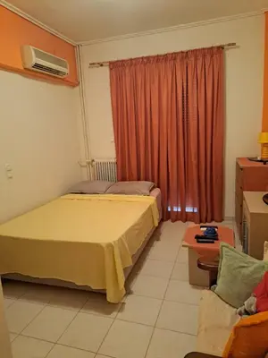 a bedroom with a bed and a couch and a window at Minimal Stoudio in Athens