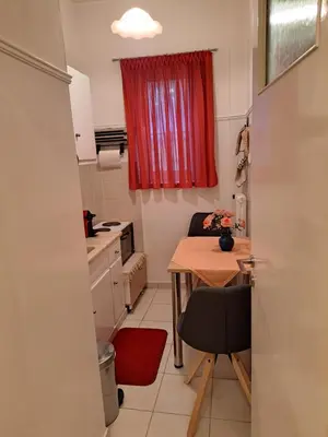 a small kitchen with a table and a red window at Minimal Stoudio in Athens