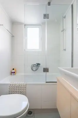 a white bathroom with a toilet and a sink at Sunny southern Athens flat near the seaside in Athens