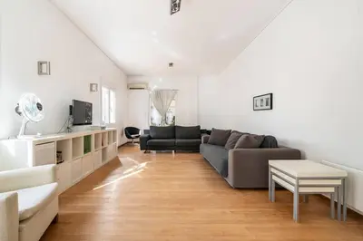 a living room with a couch and a table at Sunny southern Athens flat near the seaside in Athens