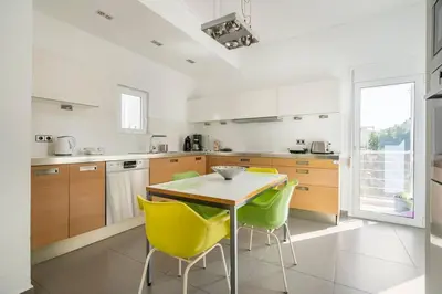 a kitchen with a table and yellow chairs at Sunny southern Athens flat near the seaside in Athens