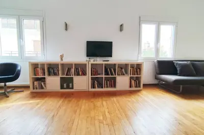 a living room with a television and a book shelf at Sunny southern Athens flat near the seaside in Athens