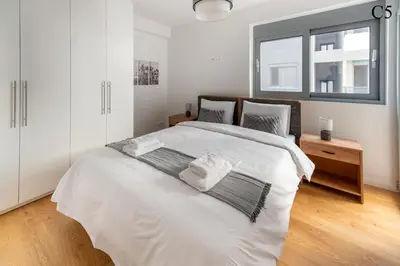 a bedroom with a large white bed with a window at Waylink Residences - Marina Floisvou in Athens