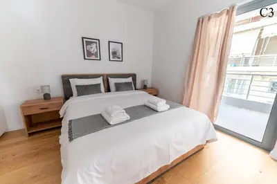 a bedroom with a large white bed and a window at Waylink Residences - Marina Floisvou in Athens