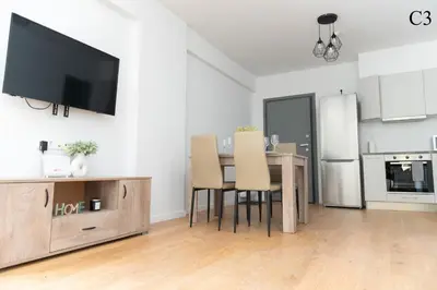 a living room with a dining room table with a flat screen tv at Waylink Residences - Marina Floisvou in Athens