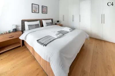 a large white bed in a bedroom with a wooden floor at Waylink Residences - Marina Floisvou in Athens