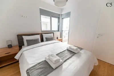 a bedroom with a large white bed with towels on it at Waylink Residences - Marina Floisvou in Athens