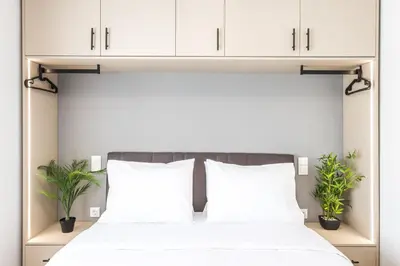 a bedroom with a bed with white cabinets and plants at Raise Area 41 in Athens