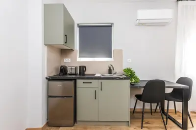 a kitchen with a sink and a table and chairs at Raise Area 41 in Athens