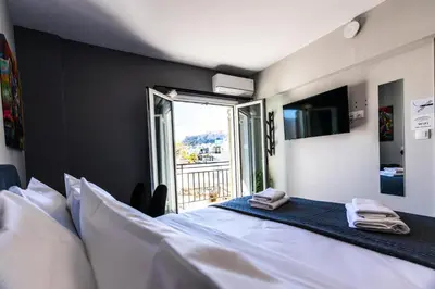 a bedroom with a large white bed and a window at Raise Area 41 in Athens