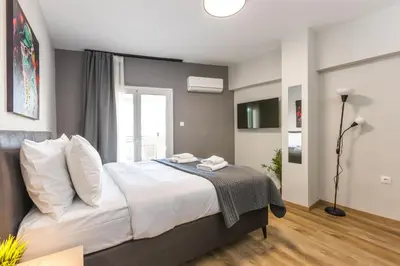 a bedroom with a bed with white sheets and a window at Raise Area 41 in Athens