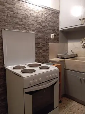 a kitchen with a white stove and a sink at Bunk bed in dorm 5' from metro in Athens