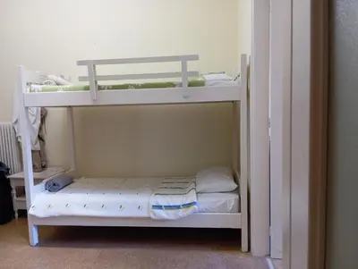 a small bedroom with two bunk beds in a room at Bunk bed in dorm 5' from metro in Athens