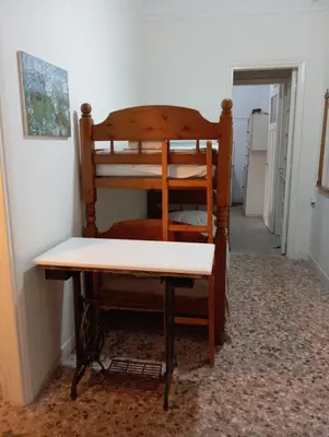 a chair and a table in a hallway at Wooden bunk bed in a dorm 5' from metro in Athens