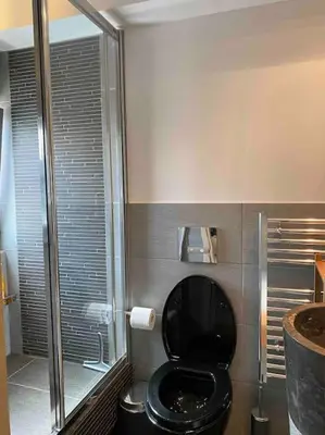 a bathroom with a black toilet and a shower at Top roof luxury studio near metro! in Athens