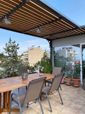 a wooden table and chairs on a patio at Top roof luxury studio near metro! in Athens