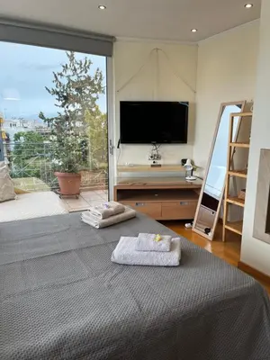 a bedroom with a bed and a large window at Top roof luxury studio near metro! in Athens