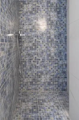 a bathroom with a shower with blue tiles at Flat by the Beach Voula in Athens