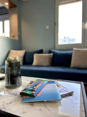 a glass table with a book on top of it at Flat by the Beach Voula in Athens