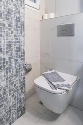 a bathroom with a toilet and a glass shower at Flat by the Beach Voula in Athens