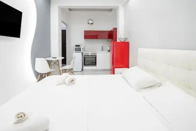 a white room with two beds and a kitchen at Estia in Athens