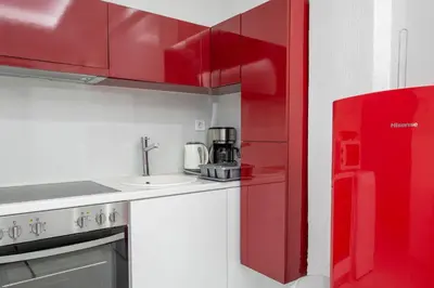 a red kitchen with a sink and a red refrigerator at Estia in Athens