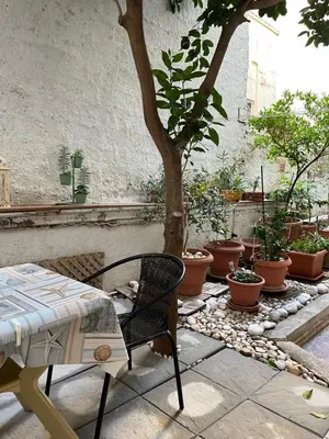 a table and chair on a patio with potted plants at Cozy ground floor studio near metro! in Athens