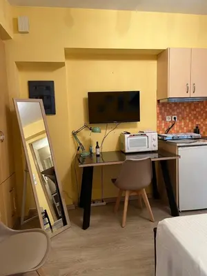 a kitchen with a table with a microwave on it at Cozy ground floor studio near metro! in Athens