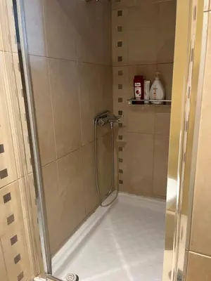 a shower with a glass door in a bathroom at Cozy ground floor studio near metro! in Athens