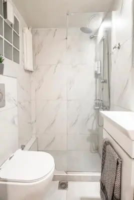 a white bathroom with a shower and a toilet at Ifigenia in Athens