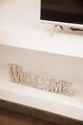a silver welcome sign on a tv shelf at Ifigenia in Athens