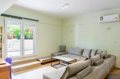 a living room with a couch and a window at Dousma Apartment in Athens