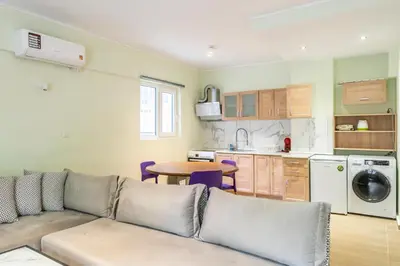 a living room with a couch and a kitchen at Dousma Apartment in Athens