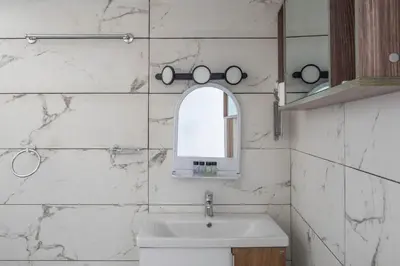 a white bathroom with a sink and a mirror at Andre Apartment in Athens