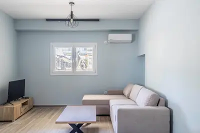 a living room with a couch and a tv at Andre Apartment in Athens