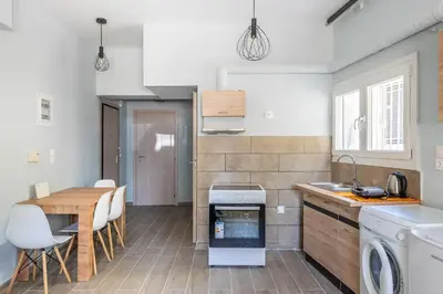 a kitchen and dining room with a table and a stove at Andre Apartment in Athens