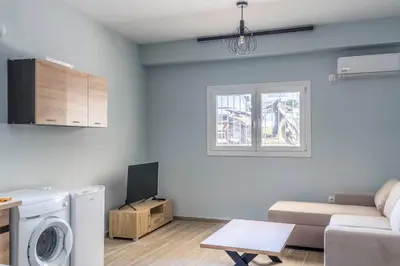 a living room with a couch and a washer at Andre Apartment in Athens