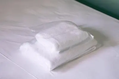 a stack of white towels sitting on a bed at Andre Apartment in Athens