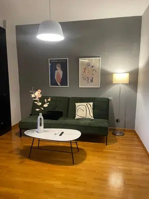 a living room with a green couch and a table at Exarcheia Athens Penthouse in Athens
